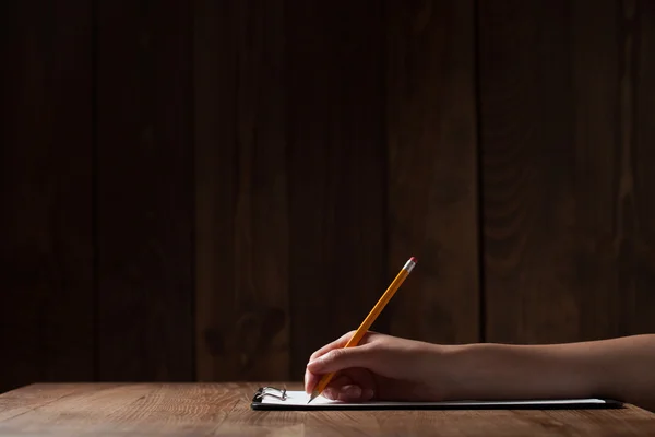 Scrittura a mano della donna su carta sopra il tavolo di legno — Foto Stock