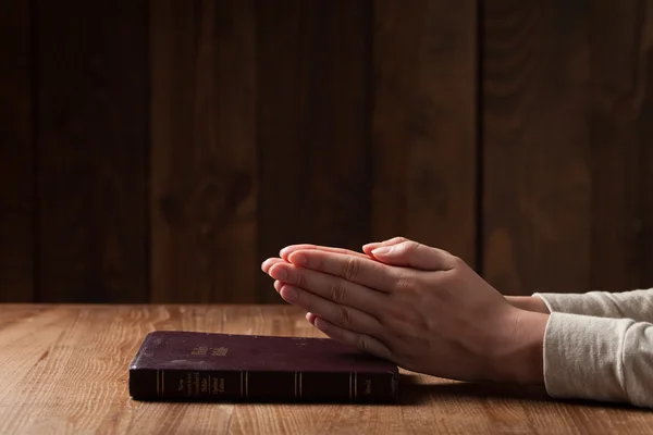 Las manos de la mujer en la Biblia. está leyendo y rezando sobre la Biblia — Foto de Stock