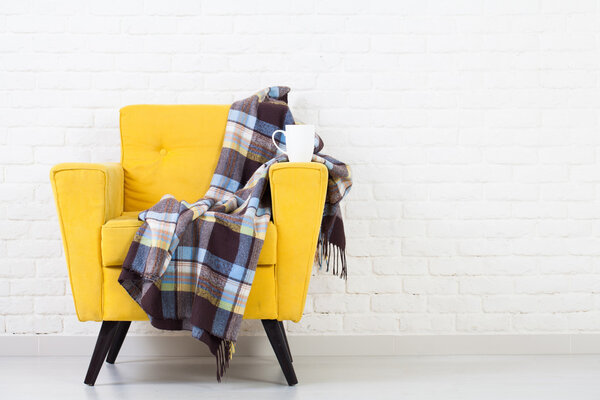 Текстура белой стены с ретро-желтым креслом
