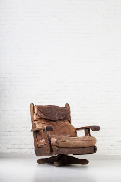 leather retro armchair next to a wall