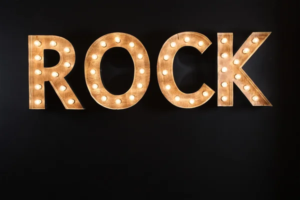 Señal de roca hecha de bombillas sobre fondo negro — Foto de Stock