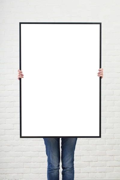 Mulher com cartaz em branco no fundo da parede — Fotografia de Stock