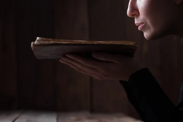 Женщина раздувает пыль из книги — стоковое фото