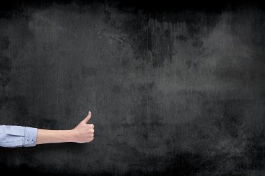 El başparmak üzerinde tahta arka plan ile