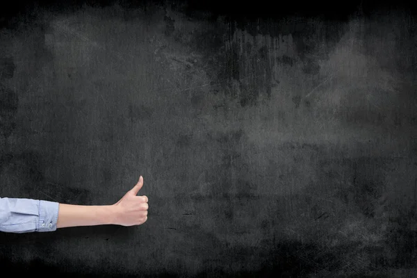 Hand with thumb up over blackboard background — Stock Photo, Image