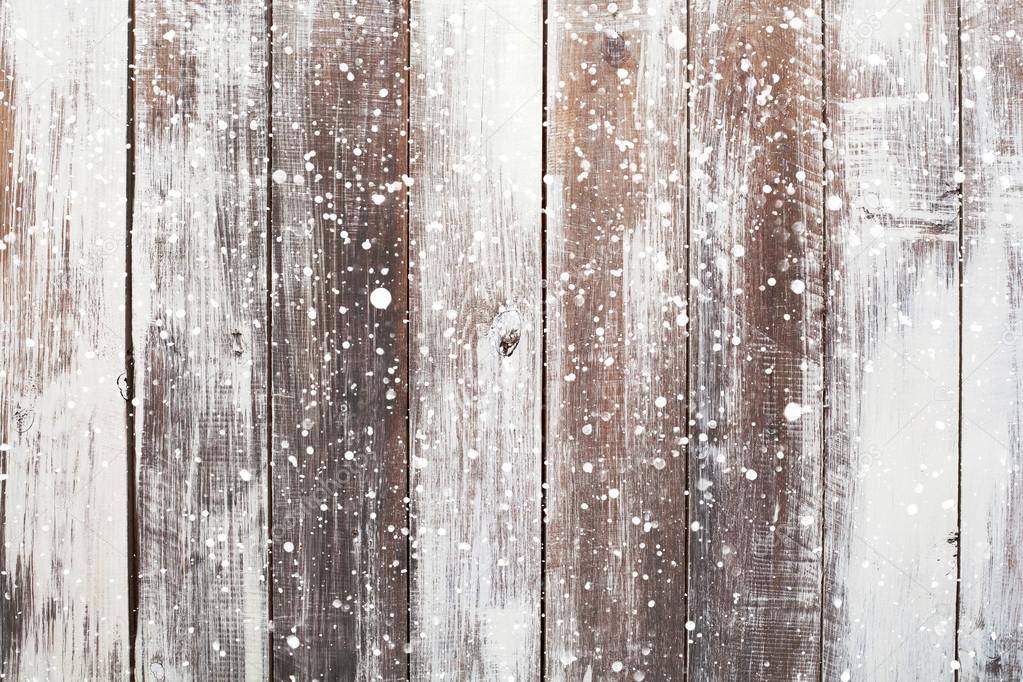 Christmas background with falling snow over wooden background