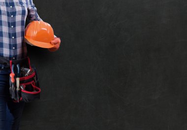 İşçi ve kadın ile toolbelt koyu arka plan karşı kask