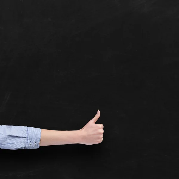 Hand with thumb up over blackboard background — Stock Photo, Image