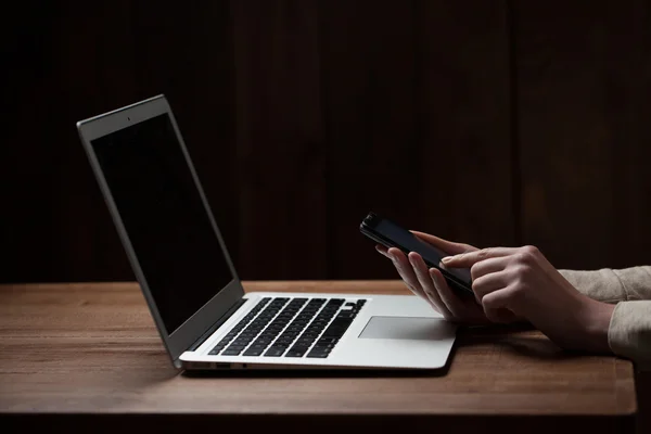 Mãos de mulher usando laptop na mesa de escritório, com copyspace no escuro — Fotografia de Stock