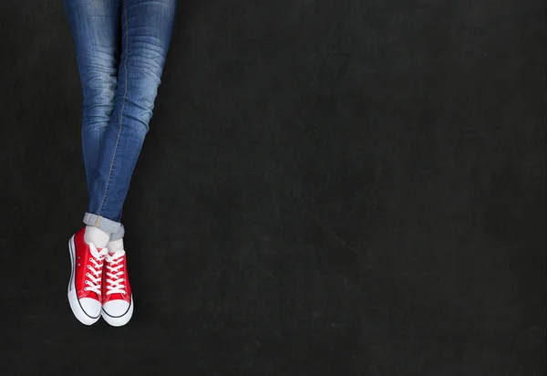 Piedi indossando scarpe rosse su sfondo nero con spazio per il testo — Foto Stock