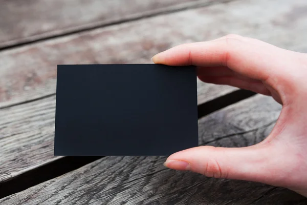 Mão segurando um negócio preto ou cartão de visita — Fotografia de Stock