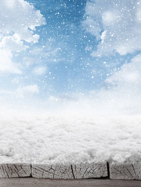 Empty winter background of wooden table and sky with falling sno — Stock Photo, Image