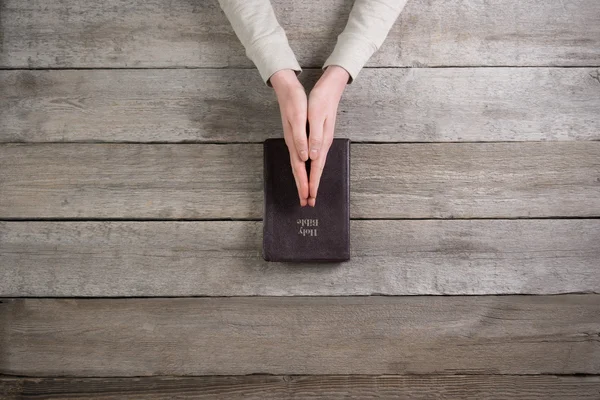 Vrouw handen op Bijbel. Ze is lezen en bidden over Bijbel over — Stockfoto