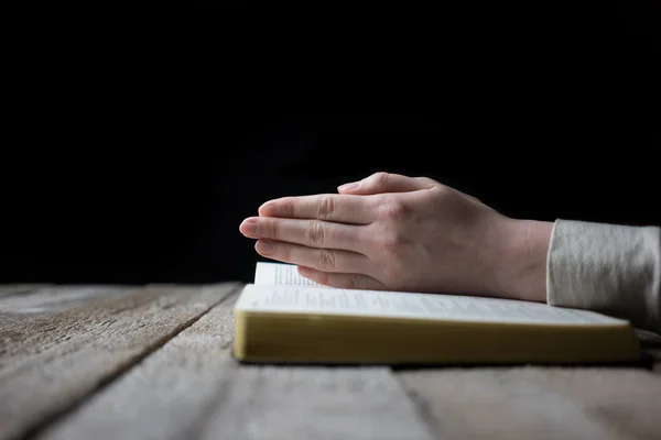 Las manos de la mujer en la Biblia. está leyendo y rezando sobre la Biblia — Foto de Stock