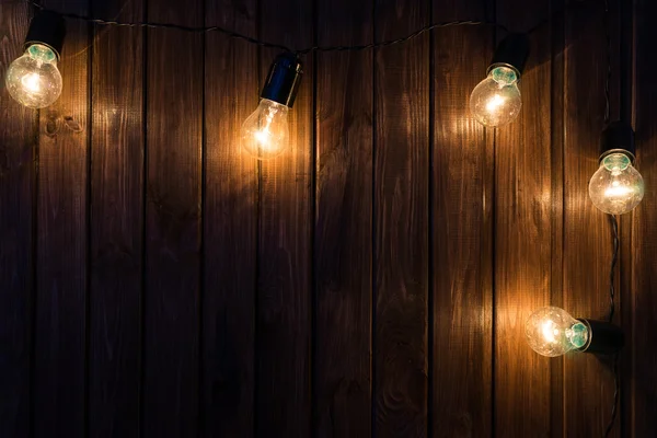 Glühbirnen auf dunklem Holzhintergrund — Stockfoto