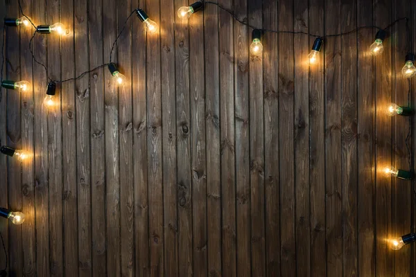 Bombillas de luz sobre fondo de madera oscura imagen real — Foto de Stock
