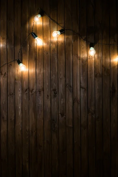 Bombillas de luz sobre fondo de madera oscura imagen real — Foto de Stock