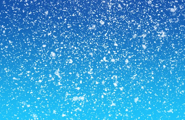 Fallender Schnee auf blauem Hintergrund — Stockfoto