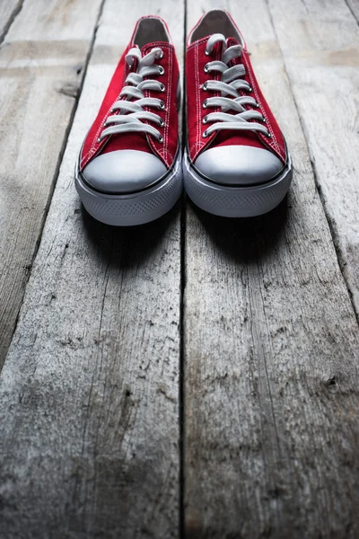 Scarpe da ginnastica rosse su sfondo legno — Foto Stock