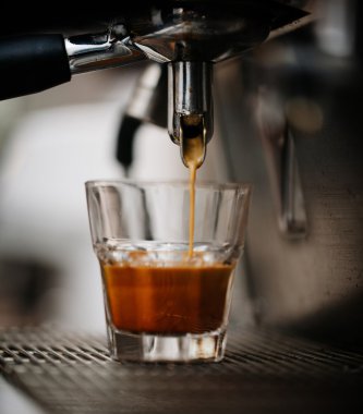 bir bardağa dökülür varlık kahve