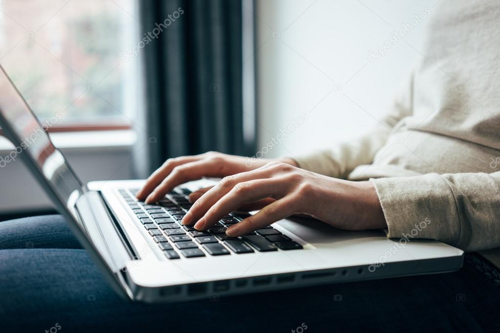  Woman sitting on sofa using laptop