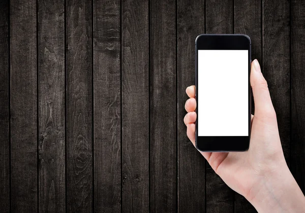 Female hand holding smart phone on wooden background — Stock Photo, Image