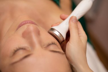 Kozmetik Güzellik Kliniği 'nde kadınların yüz bakımı mikro cilt bakımı yaptırırken yakın plan çekimleri. Hidra Elektrik süpürgesi temizleyicisi. Deri dökülmesi, gençleştirme ve susuzluk. Kozmetoloji. Yüz Cildi Bakımı.