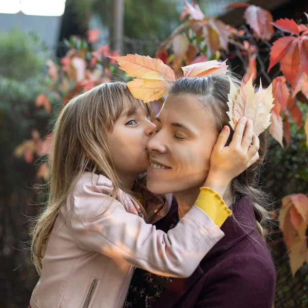 Yaşında Küçük Bir Kız Annesini Öpüyor Sonbahar Yapraklarının Arka Planına — Stok fotoğraf
