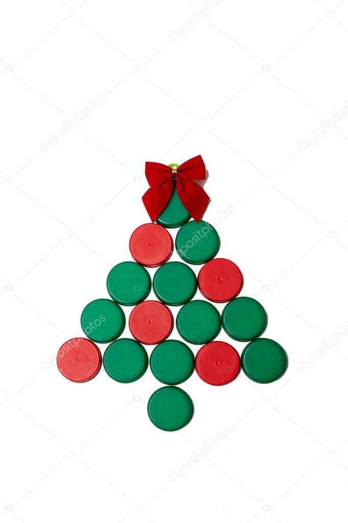 Christmas tree made of plastic covers on a white background. Eco friendly recyclable plastic concept. Flat lay