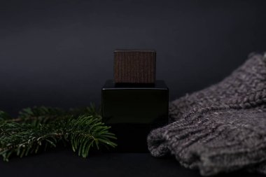 Parfüm, erkek parfümü ya da siyah arka planda tıraş sonrası parfümü erkek süveteri ve iğnelerinin yanında, Spruce. Lüks, Hediye. Bir parfüm dükkanının reklamını yapmak için yakın plan fotoğraf, blog