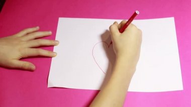 Çocuk elleri beyaz kağıtlara kalp çizer. Çocuk masaj yaz. Seni seviyorum. Video tebrik kartı kavramı