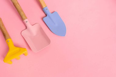 Bahçeyle ilgilenmek için pembe arka planda üç bahçe malzemesi ve fotokopi alanı. Bahar ve bahçıvanlık konsepti. Blog veya web sitesi için fotoğraf