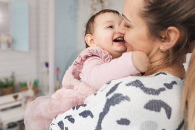 Mutlu anne ve kız 1 yaşındaki şımarık. Sarılma konsepti ve aile ilişkilerinin neşesi. Kapat.