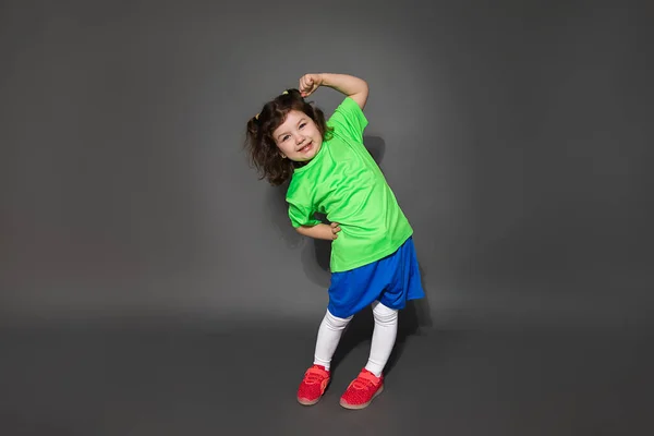 Foto Una Bambina Calciatrice Uniforme Sportiva Mostra Allenamento Sfondo Grigio — Foto Stock