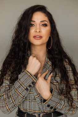 Parlak dalgalı saç stili. Ses şampuanı. Siyah kıvırcık saçlı ve parlak makyajlı. Güzellik salonu ve saç bakım konsepti.