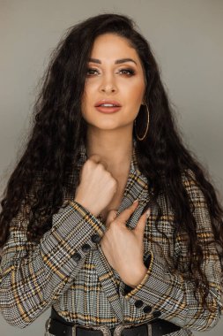 Parlak dalgalı saç stili. Ses şampuanı. Siyah kıvırcık saçlı ve parlak makyajlı. Güzellik salonu ve saç bakım konsepti.