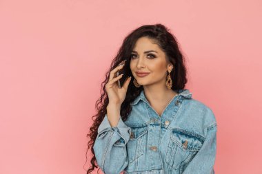 Kız telefonda konuşurken internetten alışveriş yapıyor. Pembe arka plan. Uzayı kopyala Evden çıkmadan alışveriş konsepti