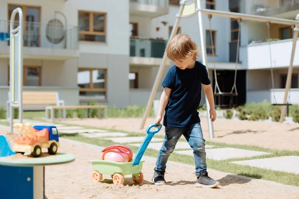 Egy Hároméves Fiú Játszik Játszótéren Homokozóban Maga Után Vonszolja Kocsit — Stock Fotó