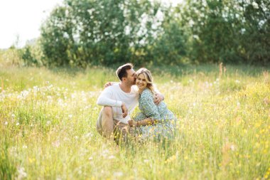 Adam çayırda sevgilisine sarılıyor kır çiçeklerinin arasında, flört kavramı, aşık oluyor.