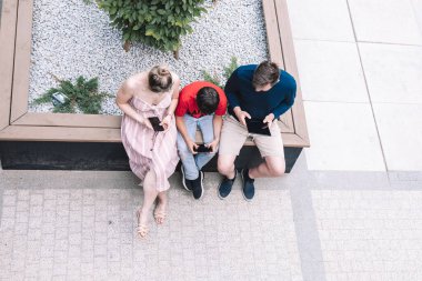 Ebeveynler ve oğulları sokakta yan yana oturuyorlar. Herkes akıllı telefonlara ya da tabletlere tutkulu. Birbirleriyle konuşmuyorlar. Telefon kullanıyorlar. .