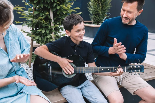 息子はギターを学ぶことに成功して両親を喜ばせる 幸せな家庭の概念 ライフスタイル — ストック写真