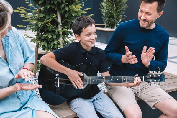 両親は息子がギターを弾くことに成功したことを喜んでいる 幸せな家庭の概念 ライフスタイル — ストック写真