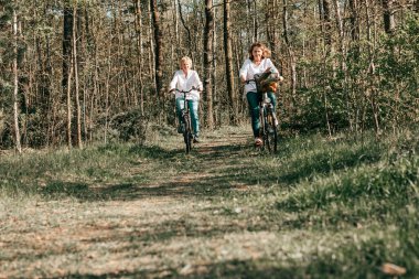 İki dişi Mathure arkadaşı ormanda bisiklet sürüyor. Aktif yaşam tarzı, hobi