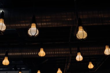 Büyük ampuller geceleri tavanda sarı yanar. Nesneler grubu. Işık ve dekorasyon. Tavan tasarımı.