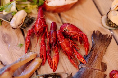 Ahşap tabakta yeşil yapraklı kerevit. Kutlama etkinlikleri. Açık büfe balık. Deniz ürünleri. Ulusal mutfak. Yaşam biçimi.