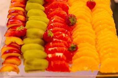 Portakal, greyfurt, kivi, şeftali ve çilek dilimleri büyük tabakta. Zevk ve zevk. Eğlence ve seyahat. Sağlıklı yaşam tarzı kavramı. Düzgün beslenme. Yaşam biçimi.