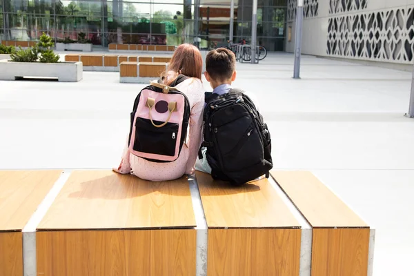 Widok Tyłu Uczniów Plecakami Siedzących Ławce Szkolnym Ogródku — Zdjęcie stockowe