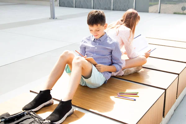 Gli Studenti Fanno Compiti Mentre Siedono Schiena Schiena Nel Cortile — Foto Stock