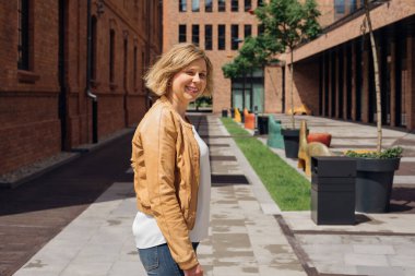  On sunny spring day, young woman walks aroundcity in great mood. Life is wonderful. Tourism and pleasure. Blogging about travel. European cities. The ability to live full life.