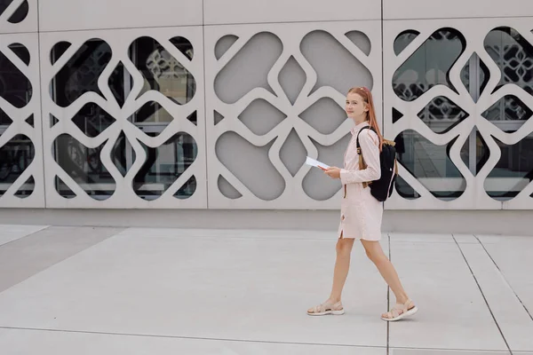 Девочка-подросток на фоне бетонного здания с рюкзаком на спине — стоковое фото